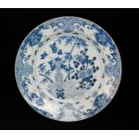 A 19th Century Chinese export blue and white charger decorated with flowers and bamboo,