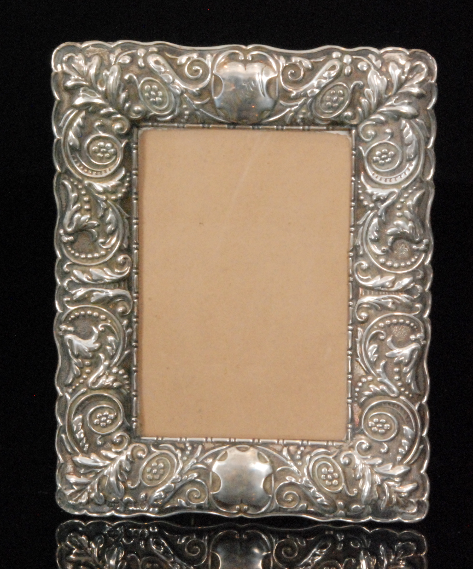 A Victorian hallmarked silver rectangular easel photograph frame profusely decorated with foliate
