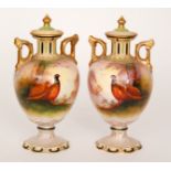 A pair of late 19th Century Crown Devon twin handled pedestal vases and covers,