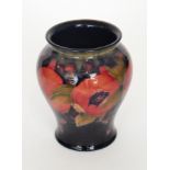 A Moorcroft Pomegranate vase of footed tapering form decorated with open and whole fruits and