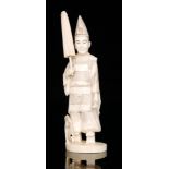 A late 19th Century Japanese carved ivory figure of a robed court official wearing a pointed hat