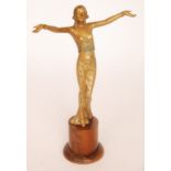 An Art Deco style gold and lacquer finished spelter figure of a lady dressed in a long flowing