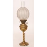 A Victorian brass oil lamp with spiral foliate pedestal and base together with shade and chimney,