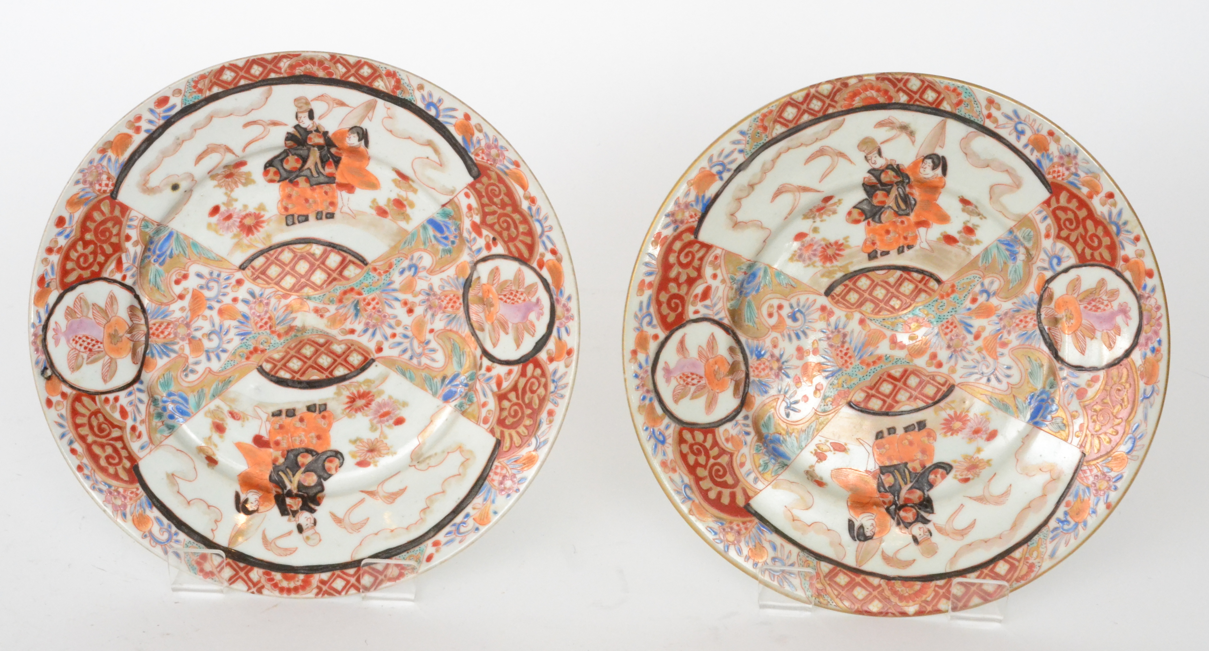 A pair of Chinese shallow plates each decorated with fan shaped cartouche panels of figures