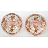 A pair of Chinese shallow plates each decorated with fan shaped cartouche panels of figures