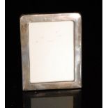 An early 20th Century hallmarked silver rectangular easel photograph frame of plain form,