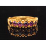 A 9ct hallmarked amethyst ring, six horizontally set claw set stones within shot detailed borders,