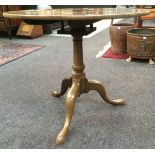 A George III mahogany circular tilt top occasional table with bird cage action on a tripod base,