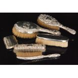 A selection of five hallmarked silver backed hand brushes,