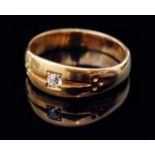 An early 20th Century high carat gold ring with central claw set old cut diamond flanked by spot