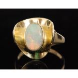 A modern 15ct opal ring, central oval collar set opal within a cupped and shaped triangular border,