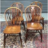 A set of four elm, ash and beech wheelback chairs with turned front legs.