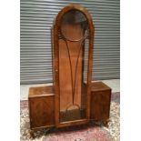 A 1930s walnut veneered side cabinet of stepped architectural form,