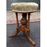 A late 19th Century circular seated walnut piano stool in the secessionist style,