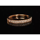 An 18ct hallmarked diamond half eternity ring comprising fifteen claw set brilliant cut stones to a