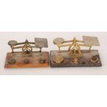 Two early 20th Century brass postal scales and weights each to a wooden rectangular base. (2).