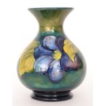 A Moorcroft vase of globe and shaft form decorated in the Clematis pattern with tubelined flowers