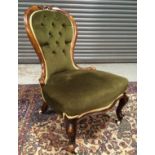 A Victorian spoonback salon chair with exposed walnut frame,