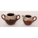 An early 20th Century cream jug and twin handled sugar bowl, unmarked but probably Doulton,