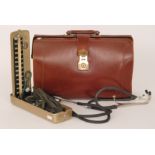 A 1930s leather doctors bag with a mahogany cased Accoson blood pressure unit,