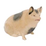 An early 20th Century money box modelled as a seated pig with sponged decoration,