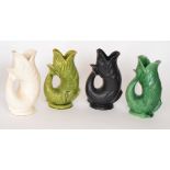 Four Dartmouth Pottery fish-shaped glug jugs comprising one black, one white and two green,