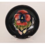 A Moorcroft shallow footed bowl decorated in the Poppy pattern with a central flower head against a