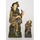 A replica Art Deco figure of a perriot singing and playing a lute and another similar small figure