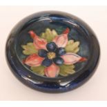 A Moorcroft roll rim bowl decorated in the Columbine pattern against a blue wash ground,