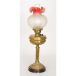 A Victorian style brass oil lamp and shade with crimped top over a reeded pedestal,