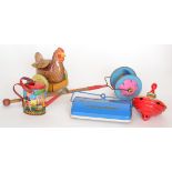 A tinplate push along toy chicken and a spinning top together with a watering can,