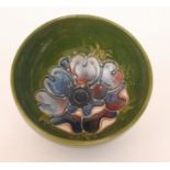 A Moorcroft high sided footed bowl decorated in the Anemone pattern with a central flower against a