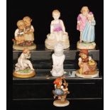 Seven assorted figures to include three Goebel Hummel figures, a Naples figure of a cherub,