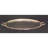 A George VI hallmarked silver twin handled oval tray of plain form with cast Celtic border,