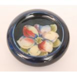 A Moorcroft roll rim bowl decorated in the Clematis pattern against a blue ground,