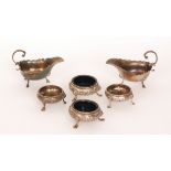 Two pairs of hallmarked silver open salts, each with embossed floral decoration on three pad feet,