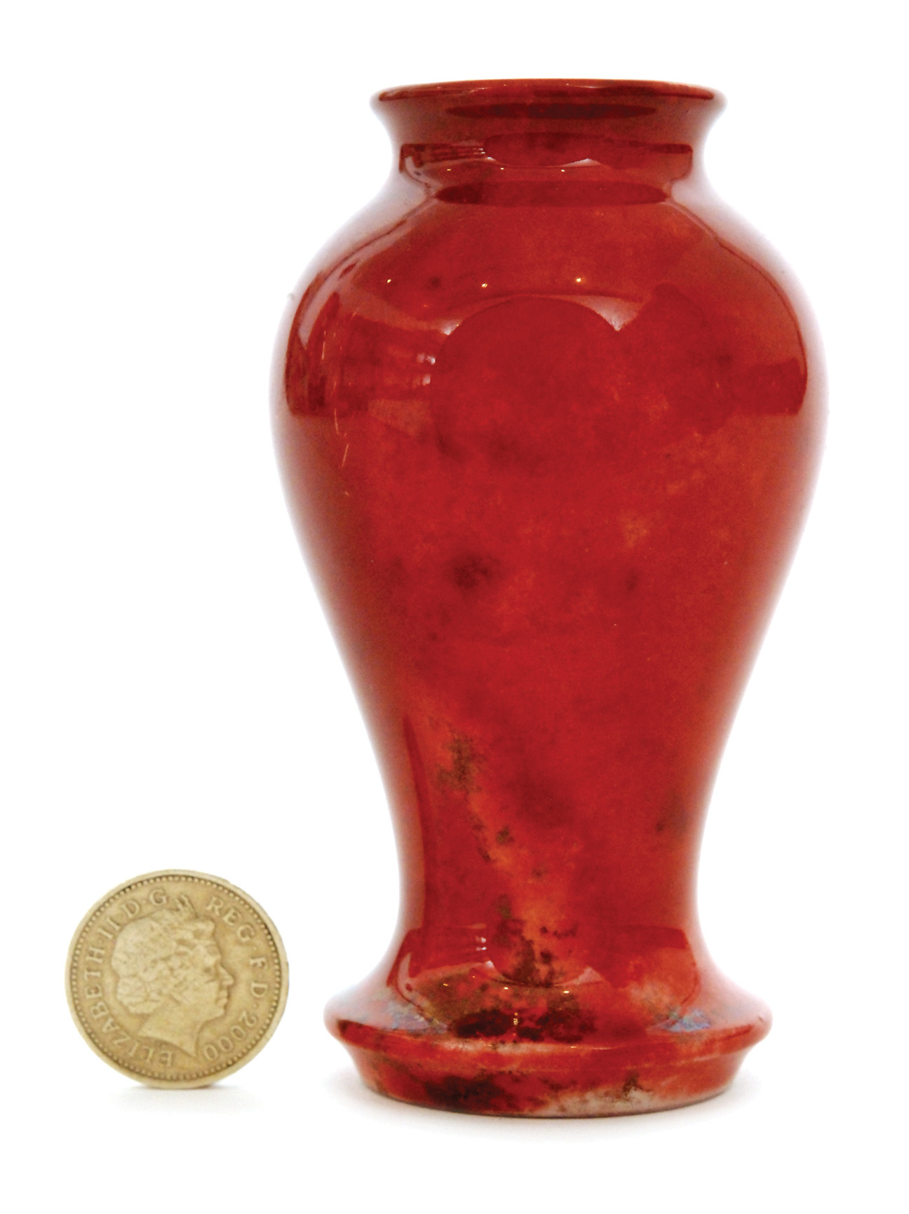 A miniature Moorcroft vase of inverted baluster form decorated in a tonal red flambe glaze,