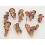 A collection of Austrian carved walnut humorous character bottle stoppers together with a Victorian