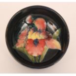 A high sided Moorcroft circular bowl decorated in the Frilled Orchid pattern against a blue ground,