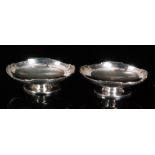 A pair of hallmarked silver oval pedestal bon bon dishes of plain form each with stepped borders,