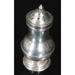 An 18th Century hallmarked silver pepper of plain baluster from terminating in spire finial,