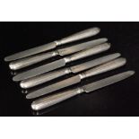 A set of six hallmarked silver dessert knives with reed handles below plain silver blades,