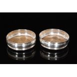 A pair of hallmarked silver bottle coasters of plain circular form, diameters 13cm, London 1968, J.