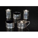 A hallmarked silver five piece cruet set of oval form with central pierced decoration, two peppers,