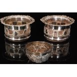 A pair of silver plated wine coasters each with broad pierced gallery with embossed swag decoration