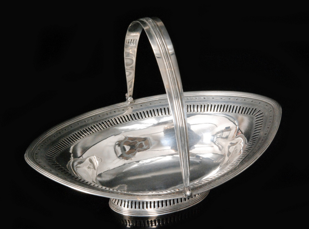 A George III hallmarked silver small swing handle pedestal basket,