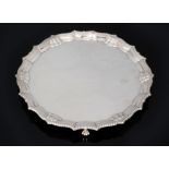 A hallmarked silver circular salver of plain form, terminating in gadroon and shell borders,