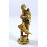 A large 19th Century carved Japanese ivory Okimono of a farmer with baskets etc., approx.