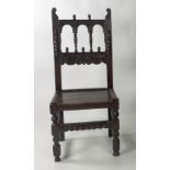 An early 18th Century carved oak Hall or Side Chair, the decorated rail back over inset solid seat,