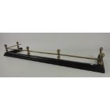 A good heavy 19th Century brass and black metal Fender, the brass rail top with turned pillars,